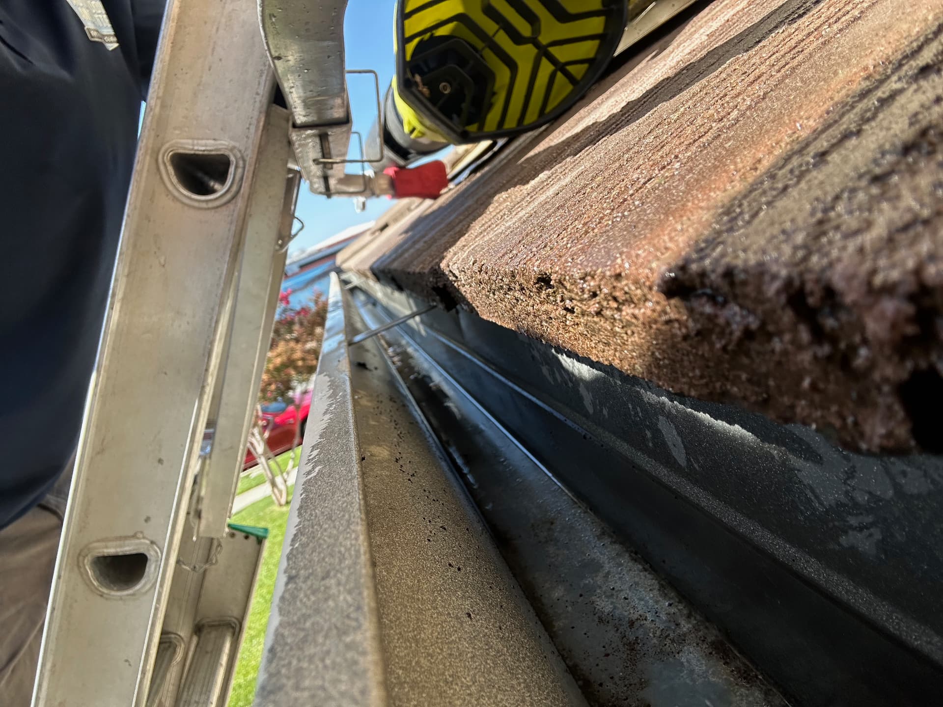 Close-up view of a technician cleaning a gutter