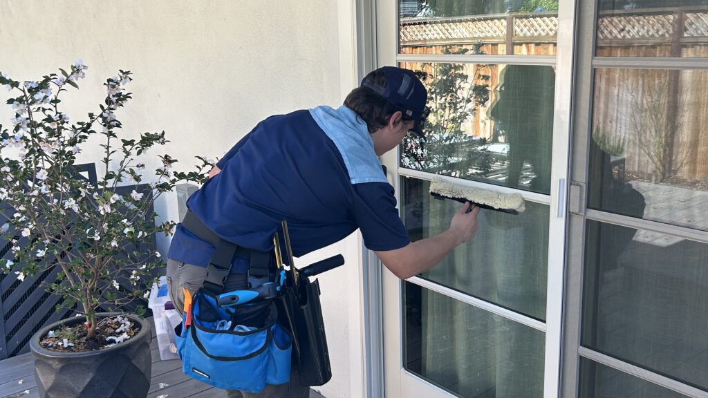 Technician cleaning exterior windows in San Jose